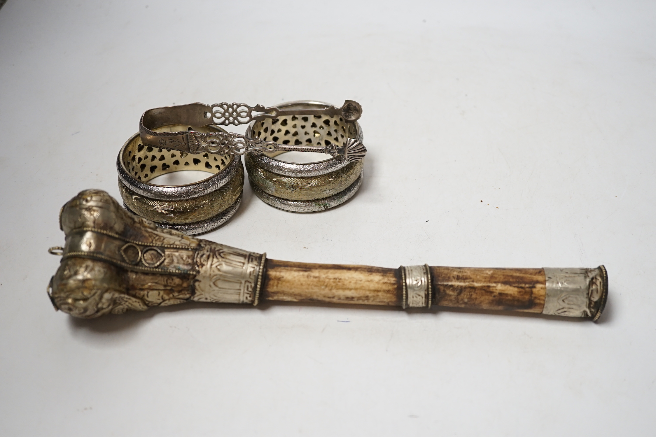 A pair of Georgian silver sugar tongs, a mounted bone implement and a pair of mixed metal bangles.